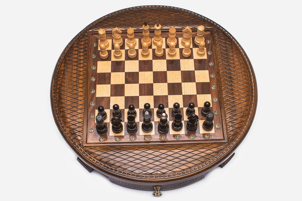 Round wooden chess set with woven lattice-carved border and Staunton pieces set up on the inlaid board