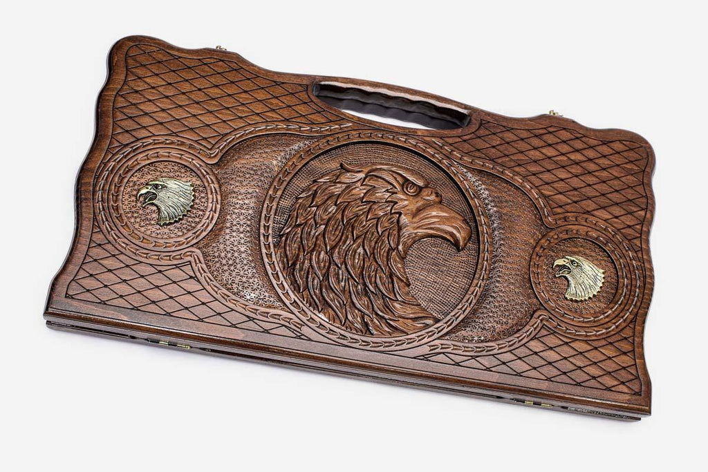 Carved beechwood backgammon board with a bronze eagle medallion, propped open