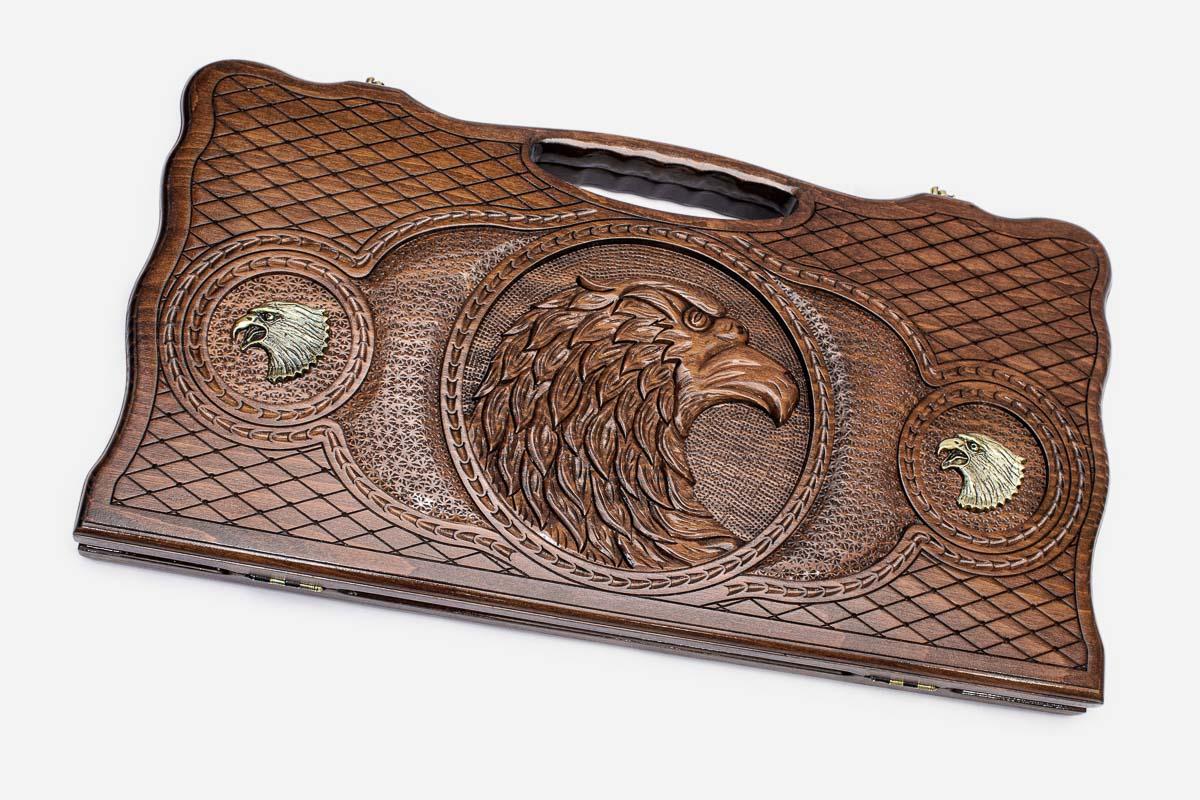 Carved beechwood backgammon board with a bronze eagle medallion, propped open