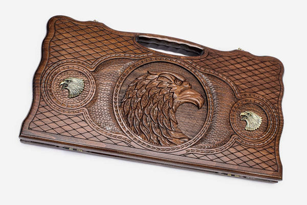 Carved beechwood backgammon board with a bronze eagle medallion, propped open