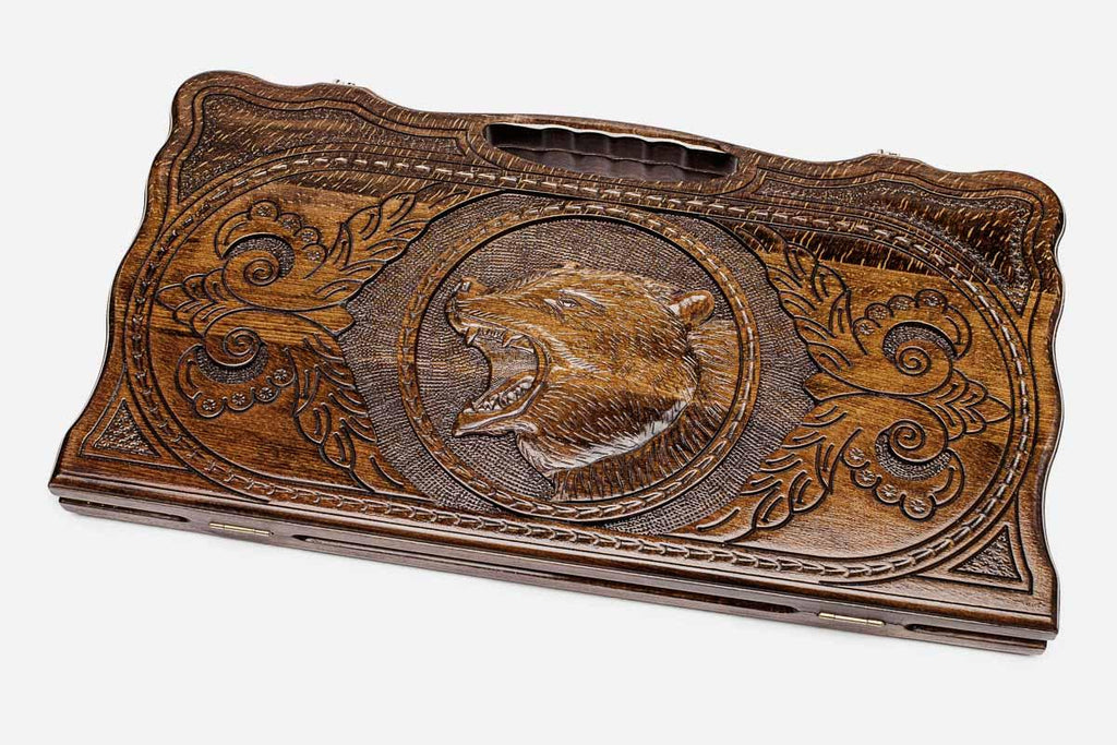 Carved beechwood backgammon board with a standing bear medallion and a carry handle, propped open