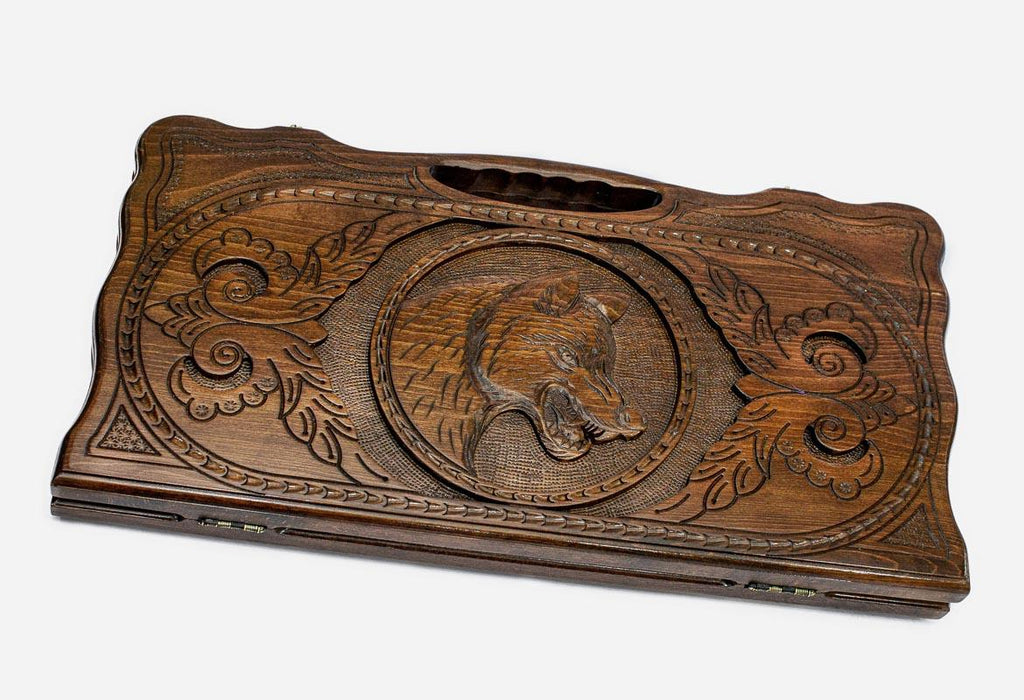 Carved beechwood backgammon board with a prowling wolf medallion and a carry handle, propped open