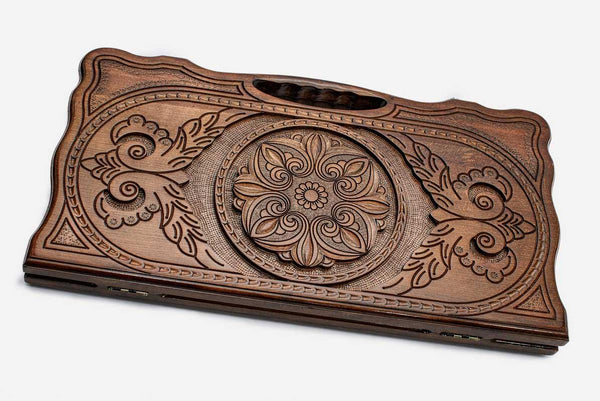 Carved beechwood backgammon board with a floral rosette medallion, propped open