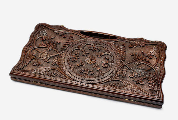 Carved beechwood backgammon board with a central rosette and floral scrollwork, propped open