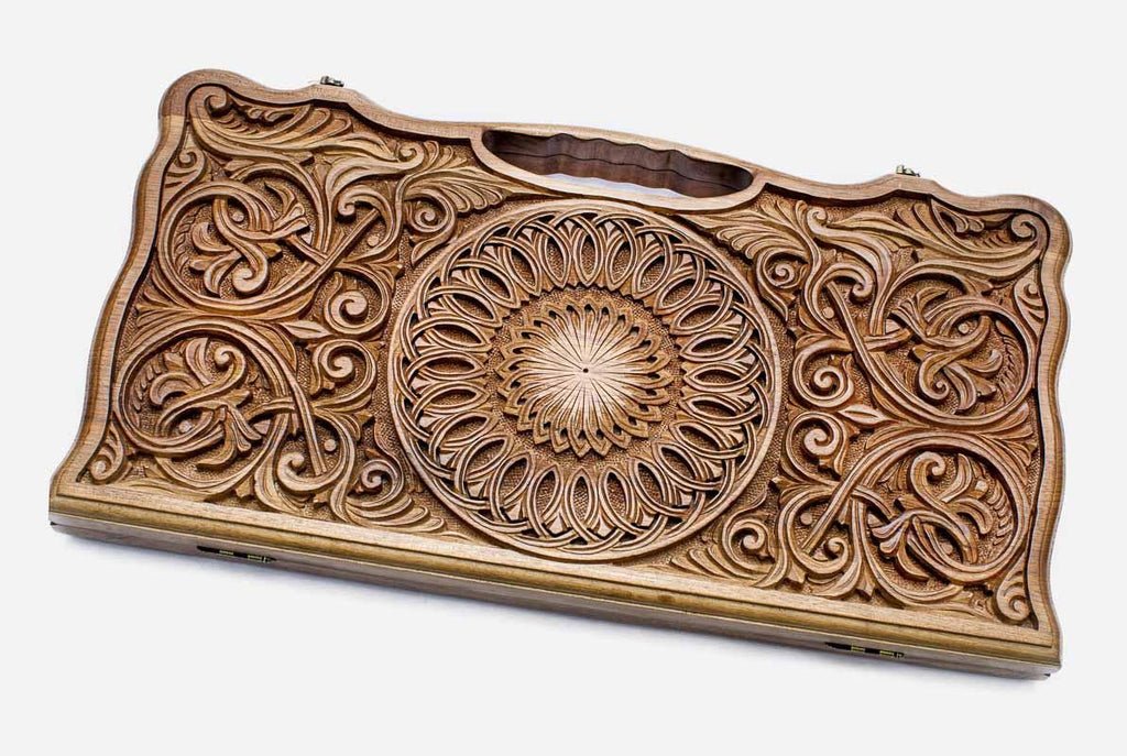 Master-carved walnut backgammon board with a central rosette and scrollwork, propped open