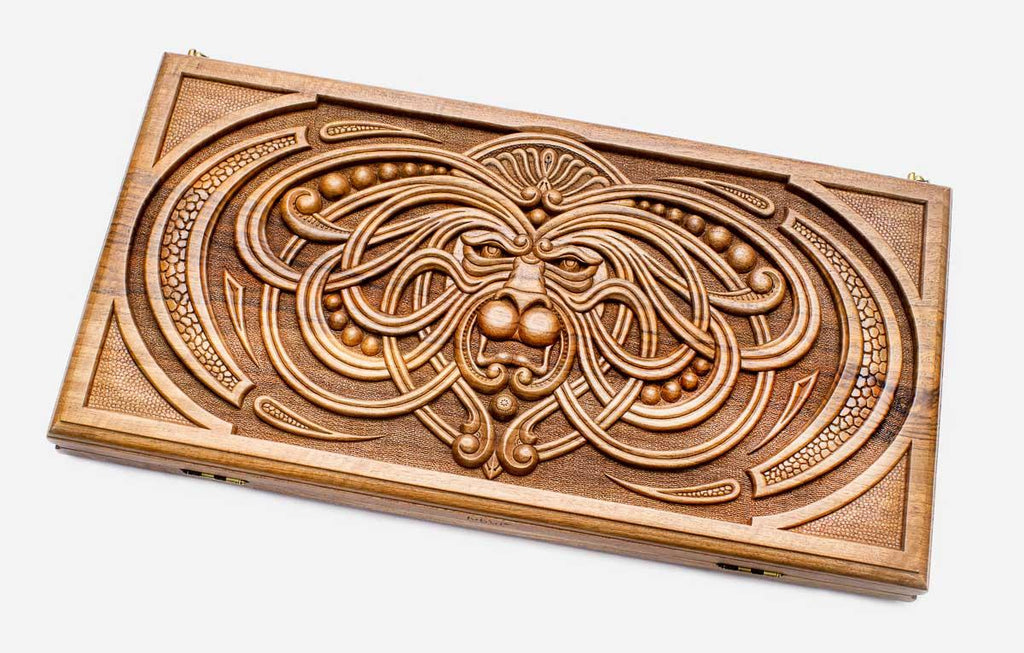 Master-carved walnut backgammon board with a symmetrical knotwork mask, propped open