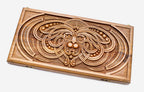 Master-carved walnut backgammon board with a symmetrical knotwork mask, propped open