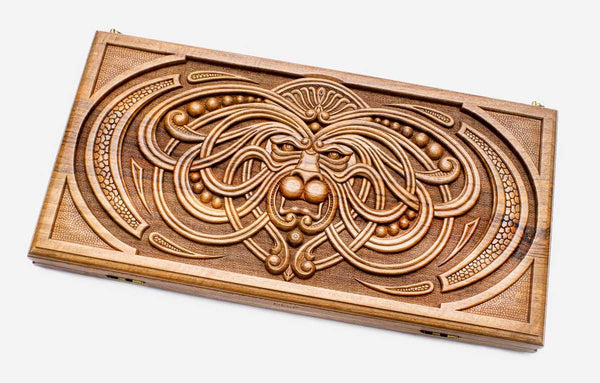 Master-carved walnut backgammon board with a symmetrical knotwork mask, propped open