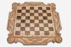 Angled view of the royal carved chess set with its wooden and bronze-crowned pieces