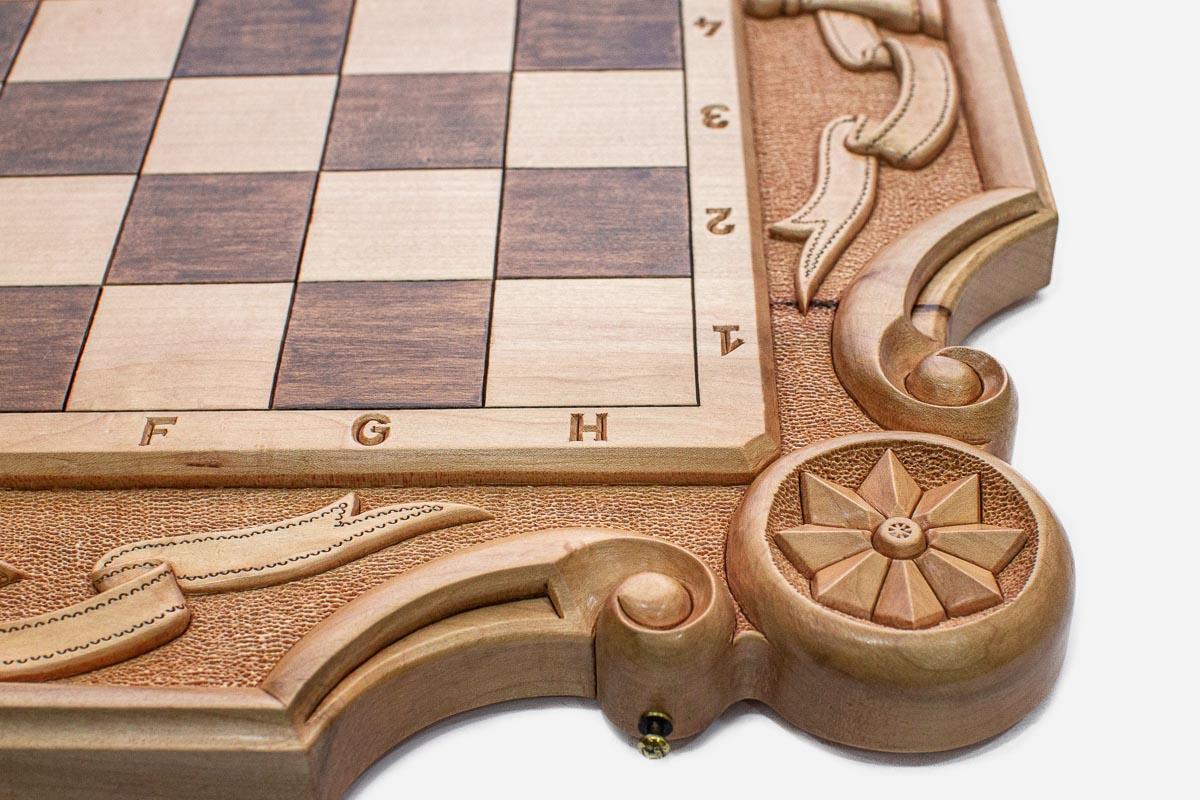 Close-up of the carved floral rosette and scrollwork corner of the board