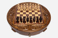 Round handmade wooden chess set with walnut and maple inlaid board and carved Staunton pieces set up for play
