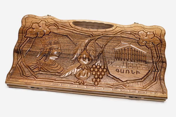 Carved walnut backgammon board with four scene medallions and a carry handle, propped open