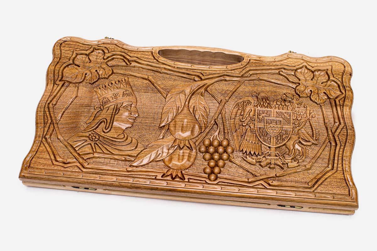 Carved walnut backgammon board with two scene medallions and a carry handle, propped open