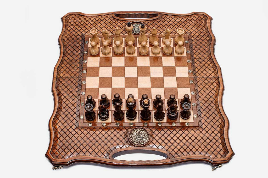 Folding chess-backgammon board with a lattice-carved border, an inlaid double-headed-eagle medallion and faceted wooden chess pieces set up for play