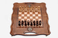 Folding chess-backgammon board with a lattice-carved border, an inlaid double-headed-eagle medallion and faceted wooden chess pieces set up for play