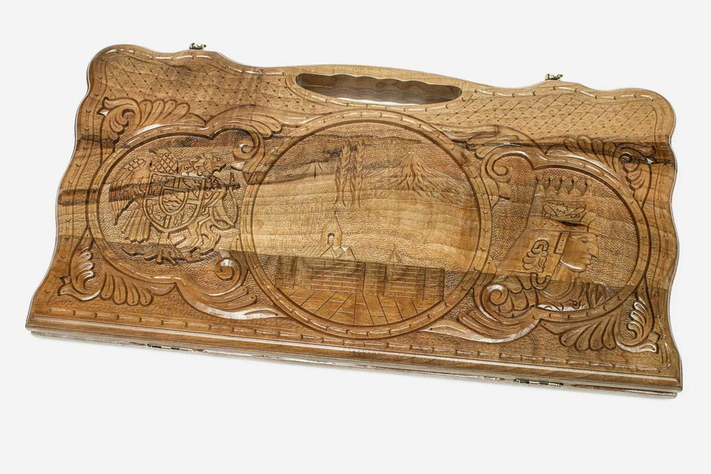 Carved walnut backgammon board with three scene medallions and a carry handle, propped open