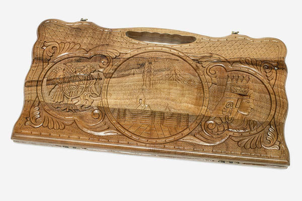 Carved walnut backgammon board with three scene medallions and a carry handle, propped open