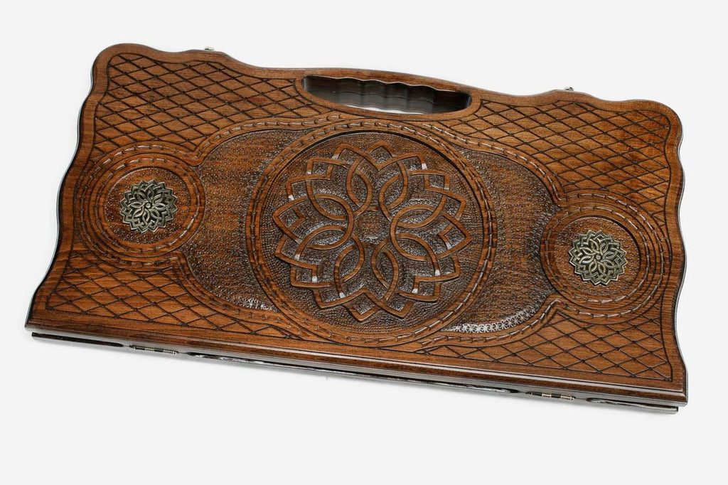 Carved beechwood backgammon board with a central rosette mandala and bronze roundels, propped open