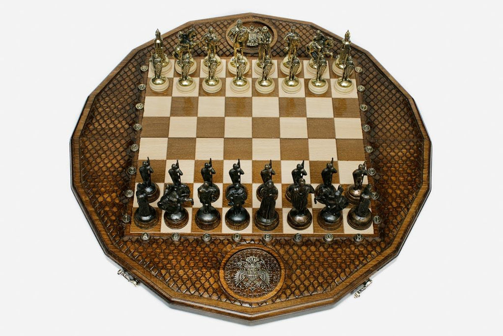 Twelve-sided carved chess board with a Russian double-headed-eagle medallion and ornate bronze figural pieces set up for play