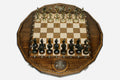 Twelve-sided carved chess board with a Russian double-headed-eagle medallion and ornate bronze figural pieces set up for play
