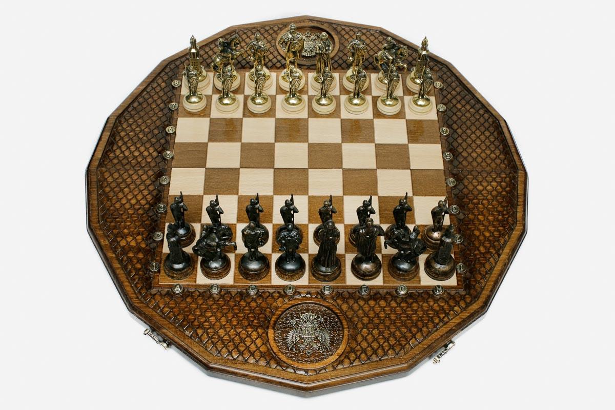 Twelve-sided carved chess board with a Russian double-headed-eagle medallion and ornate bronze figural pieces set up for play