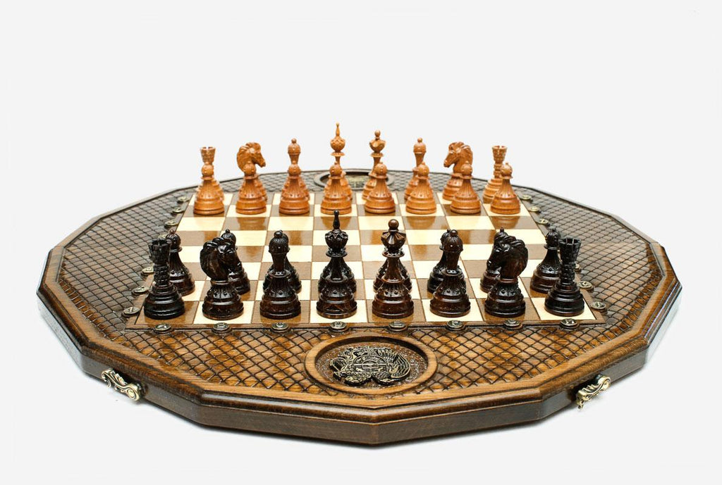 Twelve-sided carved chess board with inlaid coat-of-arms medallions and turned wooden pieces set up for play