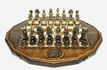 Twelve-sided carved chess board with an inlaid coat-of-arms medallion and ornate bronze figural pieces set up for play