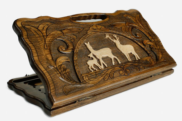Carved beechwood backgammon board with a pair of deer in a medallion and a carry handle, propped open
