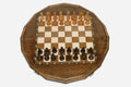 Sixteen-sided carved chess board with a lattice border and beech and walnut pieces set up for play