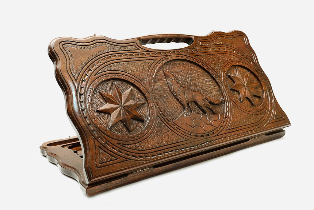 Carved beechwood backgammon board with a wolf medallion and stars, with a carry handle, propped open