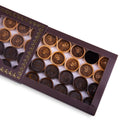 Close-up of wooden backgammon pieces with an engraved spider design.