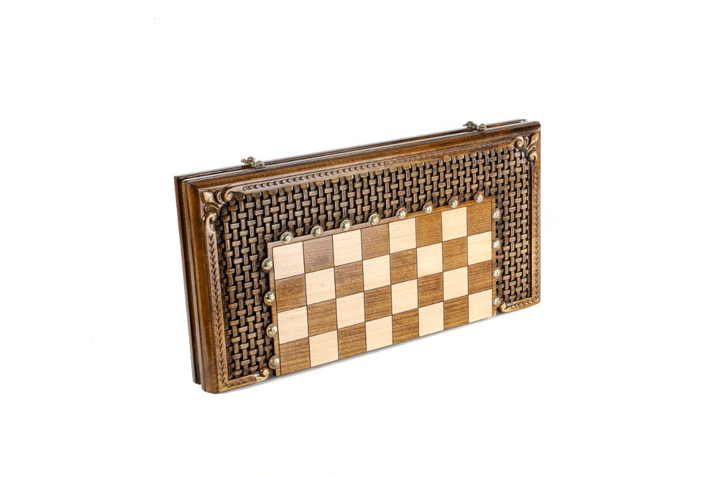 Closed wooden chess and backgammon board with woven braid ornament carved around the squares