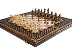 Hand-carved braid ornament border of the wooden chess board with carved pieces, close angle