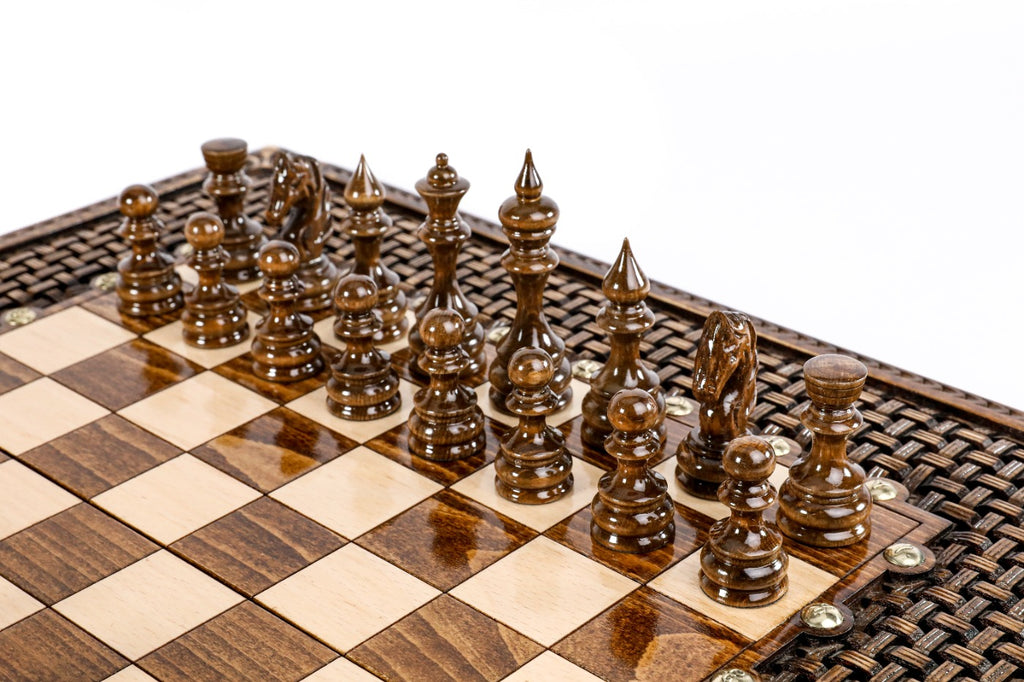 Dark hand-carved chess pieces on the beech and walnut squares beside the braid frame
