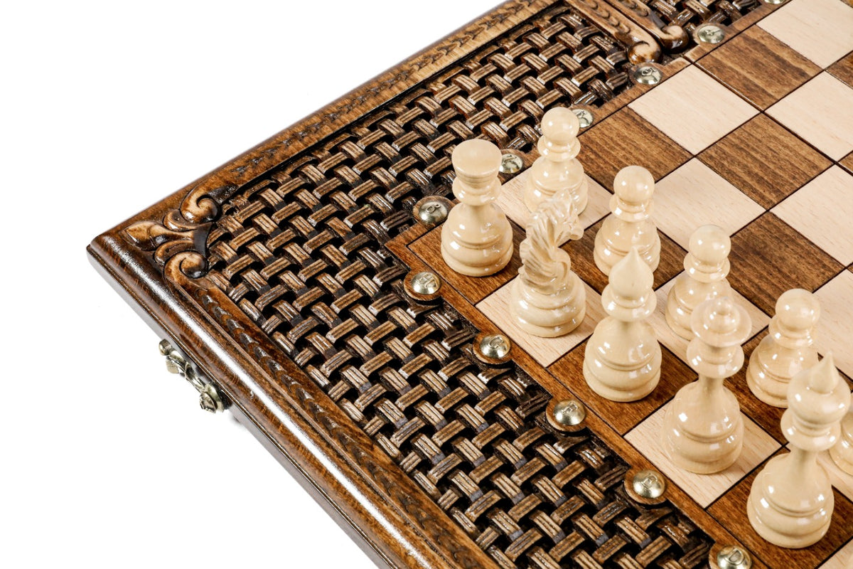 Light hand-carved chess pieces on the wooden chess board with carved braid border