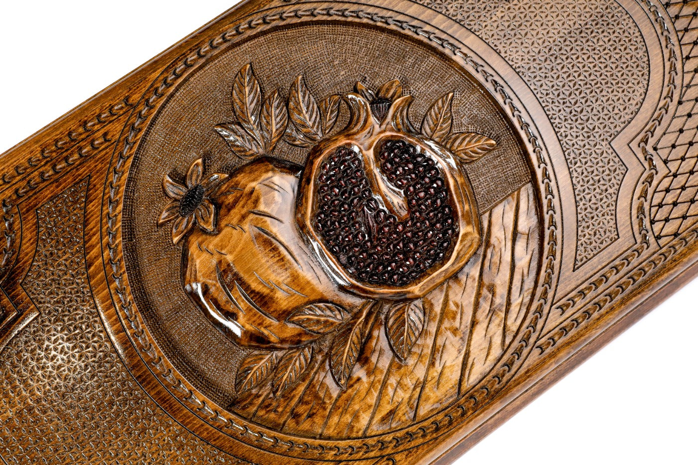 Detail view of the textured pomegranate relief on the solid wood exterior.
