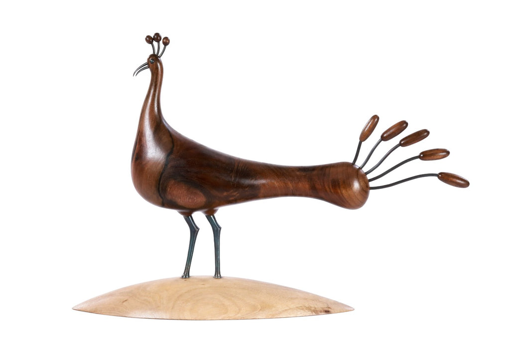 Wooden peacock sculpture with metal accents — close-up