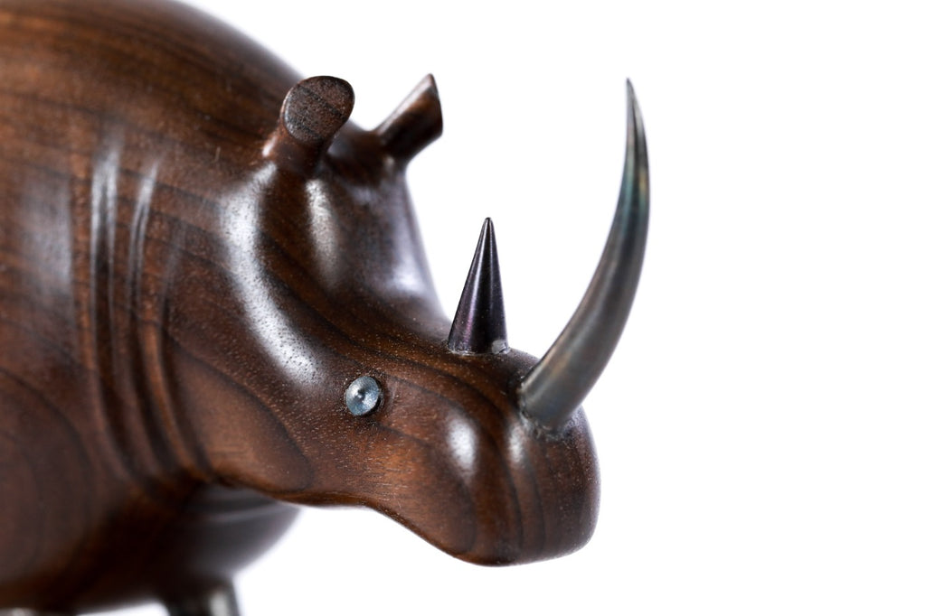 Rhinoceros sculpture in carved walnut wood — side view