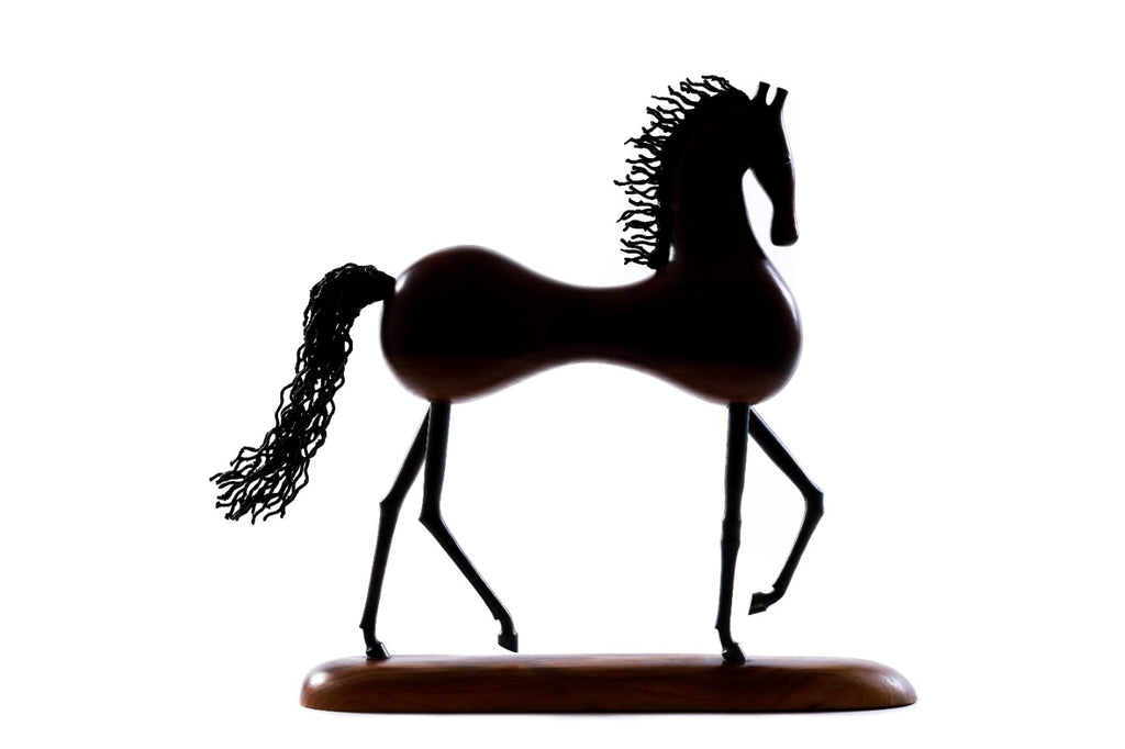 Wooden horse sculpture with metal accents — close-up