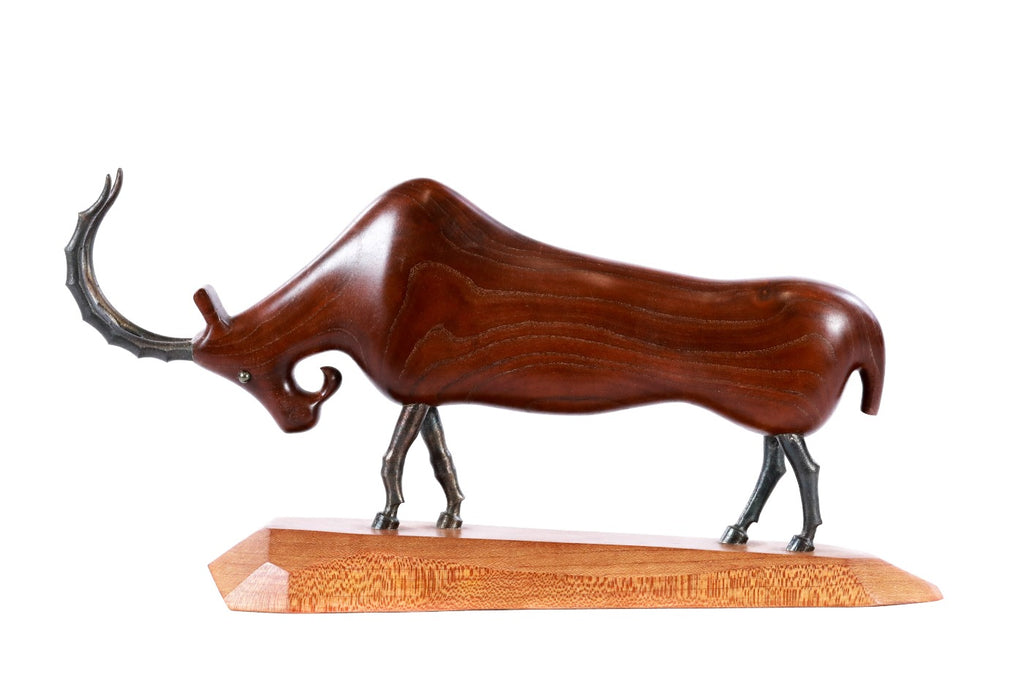 Wooden goat sculpture with metal accents — close-up