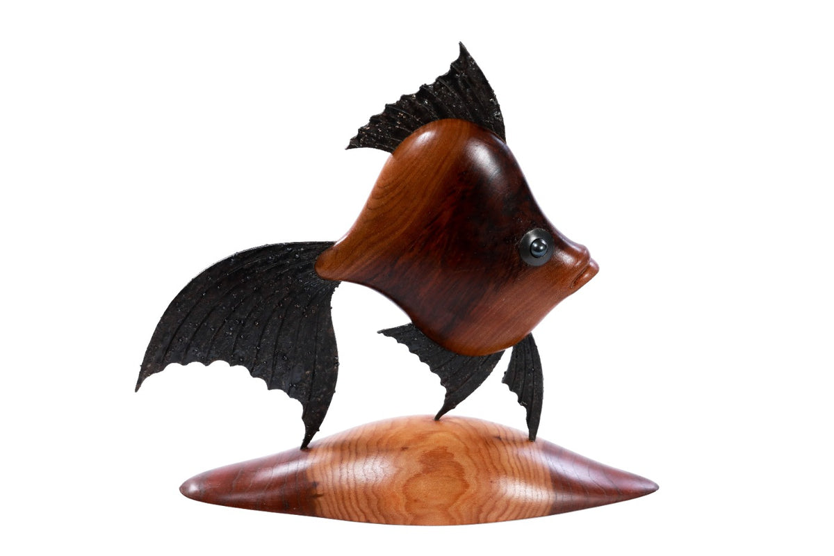 Wooden fish sculpture with metal accents — close-up
