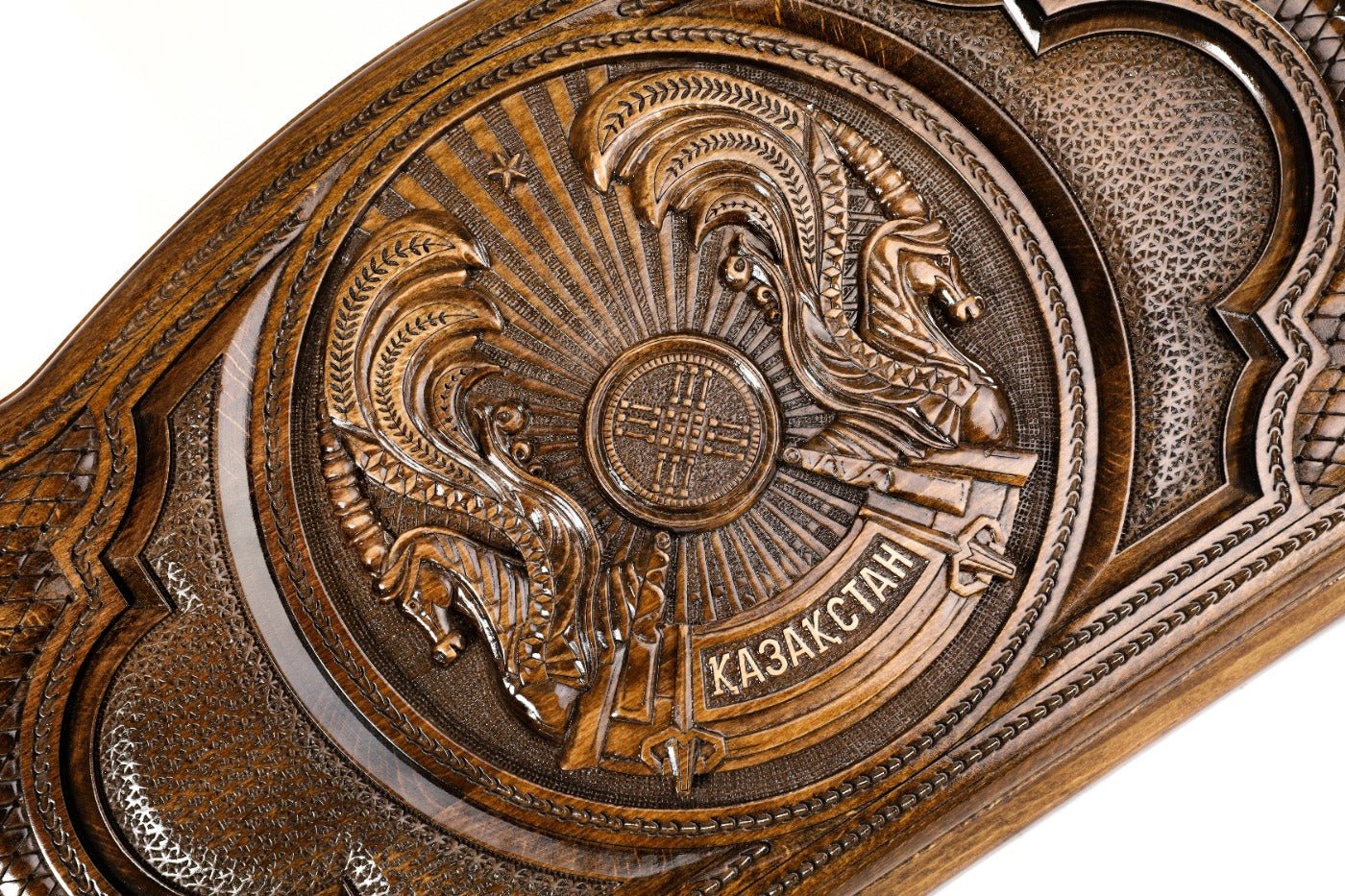 Detail view of the hand-carved Kazakh national emblem on solid wood.
