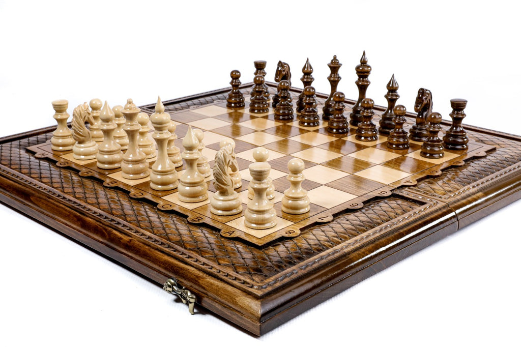 Large handmade chess board with carved lattice border and hand-carved wooden pieces, close angle