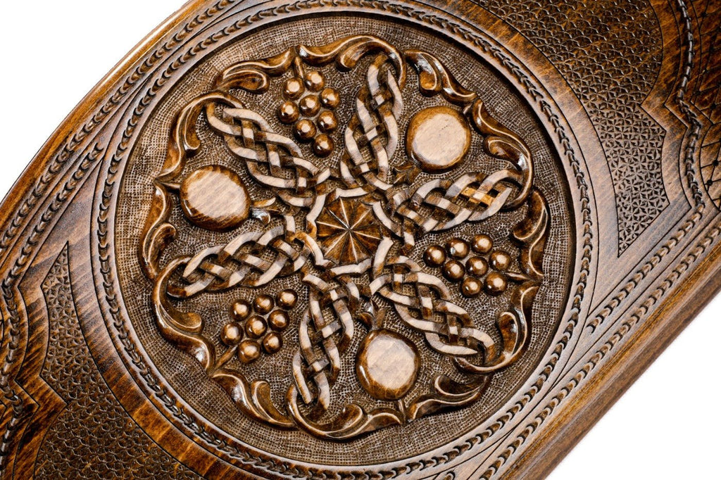 Frontal view of the intricate grapevine and pomegranate relief on the solid wood exterior.