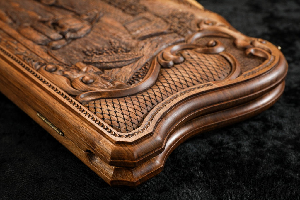 Edge of the closed walnut board with the cast-bronze clasp and the carved scroll frame