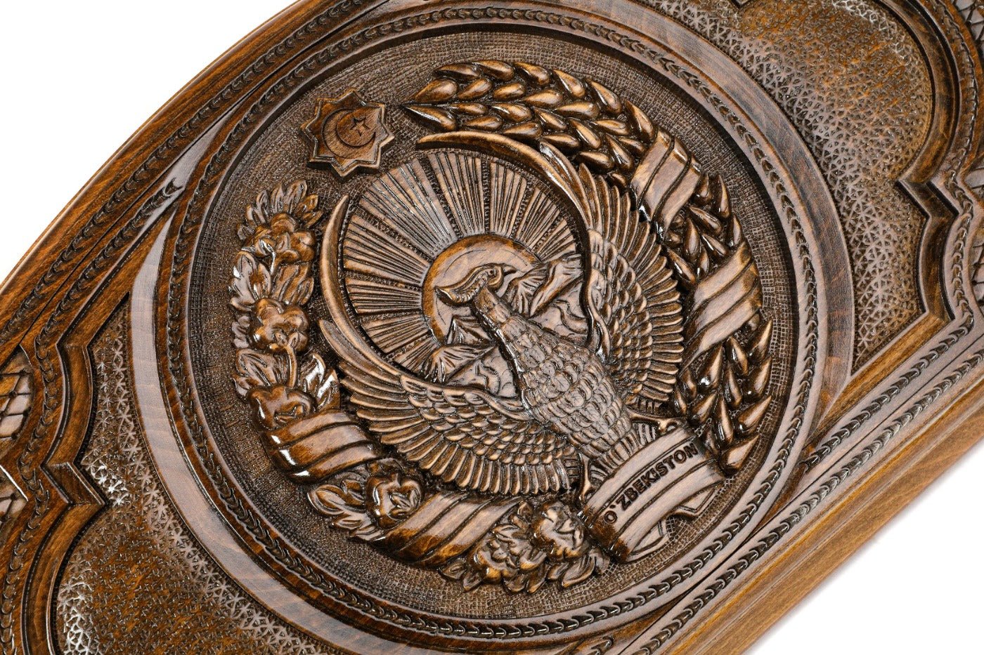 Detail view of the hand-carved Uzbek national emblem on solid wood exterior.