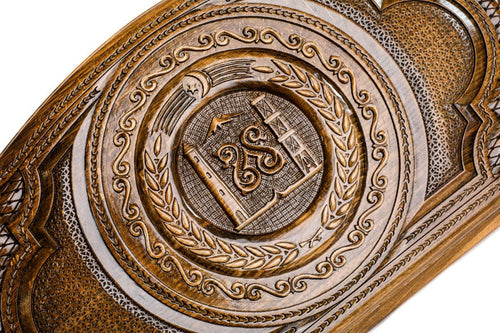 Detail view of the hand-carved Chechen national emblem on the solid wood exterior.