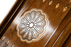 Eight-petal wheel ornament cut into the dark field of the open backgammon board