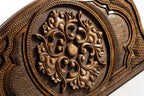 Frontal view of the detailed floral ornamental relief on the solid wood exterior.