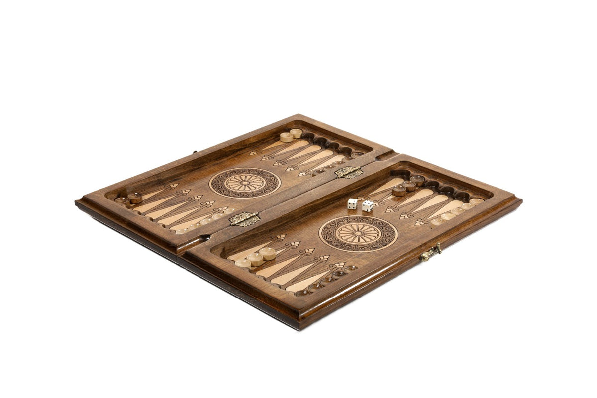 Chess and backgammon set opened to the carved backgammon field with wheel ornaments and checkers